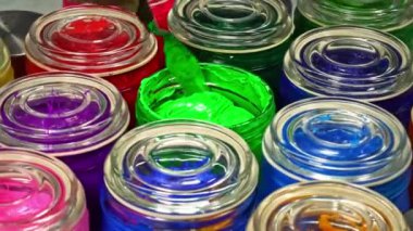 Yeşil boyayı cam kavanozda karıştırmak için bir mala kullanın. Bu renk pigmentinin karışıma eşit olarak dağılmasına yardımcı olur, böylece ürün boyunca eşit renk elde edilir..