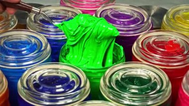 Yeşil boyayı cam kavanozda karıştırmak için bir mala kullanın. Bu renk pigmentinin karışıma eşit olarak dağılmasına yardımcı olur, böylece ürün boyunca eşit renk elde edilir..