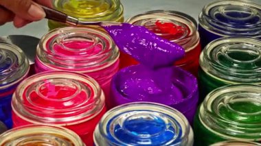 Mor kütleyi dönen bir şişede karıştırmak için bir mala kullanın. Rengi değiştirmek boyadaki pigmenti eşit olarak dağıtmaya yardımcı olur. Rengin resim boyunca aynı olduğundan emin olmak için.