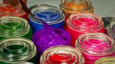 Mor kütleyi dönen bir şişede karıştırmak için bir mala kullanın. Rengi değiştirmek boyadaki pigmenti eşit olarak dağıtmaya yardımcı olur. Rengin resim boyunca aynı olduğundan emin olmak için.