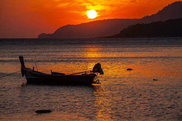 stock image amazing yellow sky of sunrise above the island, fishing boat parking on the golden sea.