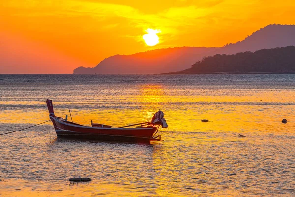 Stock image amazing yellow sky of sunrise above the island, fishing boat parking on the golden sea.