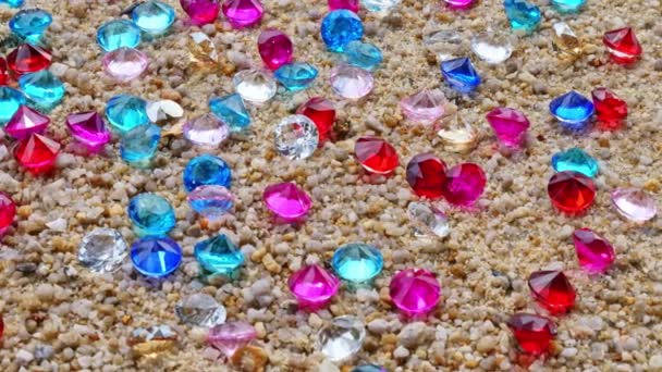 各种颜色的钻石散落在海滩上 — 图库视频影像