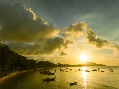 Balıkçı teknelerinin üstündeki altın gökyüzünün havadan görünüşü
