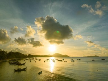 Balıkçı teknelerinin üstündeki altın gökyüzünün havadan görünüşü