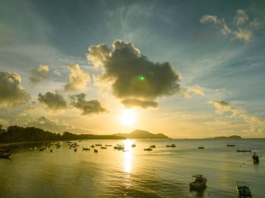 Balıkçı teknelerinin üstündeki altın gökyüzünün havadan görünüşü