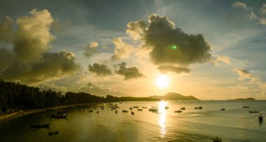 Balıkçı teknelerinin üstündeki altın gökyüzünün havadan görünüşü