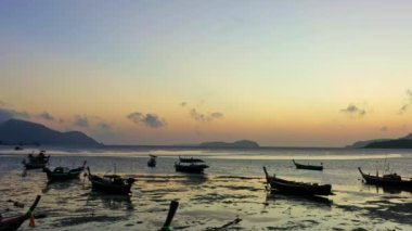 Balıkçı teknelerinin üzerindeki hava manzarası suda güzel bir yansıma yaratıyor. Denizdeki güzel güneş ışığının manzaralı yansıması Phuket denizinde yüzen balıkçı tekneleri.