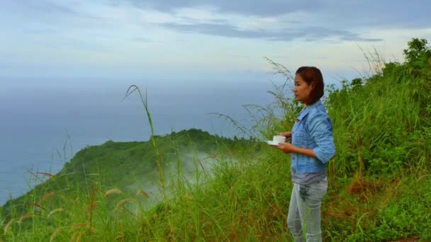 无权无势的女人在雾蒙蒙的悬崖边喝咖啡 — 图库视频影像