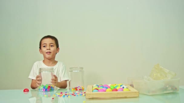 Een Leuke Jongen Speelde Vrolijk Veelkleurige Kralen Witte Kamer Hoge — Stockvideo