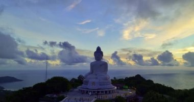 Havadan bakıldığında Phuket Büyük Buda 'nın arkasındaki bulutların arasından altın bir güneş parlıyor ve onu altın ışığıyla aydınlatıyor. Büyük Buda Phuket adasının tepesine inşa edildi..