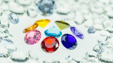 Değişik boyutlarda renkli elmaslar beyaz elmasların arka planında bir merkez daireye yerleştirilir.
