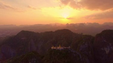 .Dağ zirvesindeki Altın Buda 'nın arkasındaki gün batımında gökyüzü renkli bulutlar. Batan güneşin aydınlattığı bulutlar güzel ve sakin bir atmosfer yaratıyor. Gökyüzü dokusu..