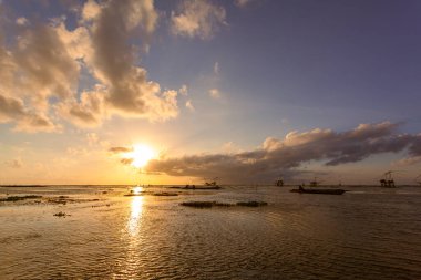 Pakistan, Tayland 'da gün doğumunda balık avlama tuzağının üstünde inanılmaz renkli bir gökyüzü.