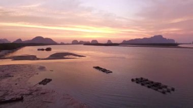 Tayland 'ın okyanus sularına yansıyan gündoğumu renklerinin havadan görünüşü. Çarpıcı sabah deniz manzarası dramatik bulutlar, yükselen güneş ve sakin su yüzeyi. 