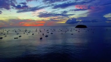 Okyanus sularına yansıyan gündoğumunun havadan görünüşü. Kata Sahili yakınlarındaki yatlar Phuket, Tayland