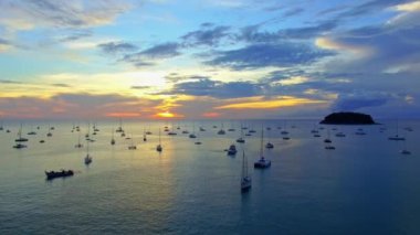 Okyanus sularına yansıyan gündoğumunun havadan görünüşü. Kata Sahili yakınlarındaki yatlar Phuket, Tayland