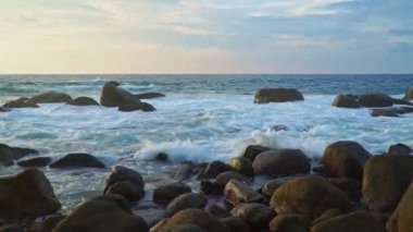 Altın güneş ışığı altındaki dalgaların videosu büyük kayalara çarptı.