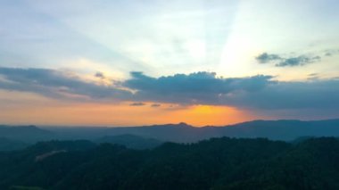 Phang Nga Vadisi 'nin dağ sırasındaki altın gün doğumu. Güneş vadideki sislerin arasından parlıyordu. Gökyüzünden gelen sarı ışık sisli vadiyi aydınlatıyordu..