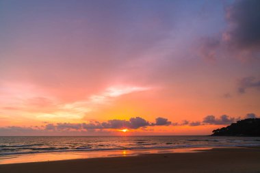 Karon plajının üzerindeki muhteşem pembe gökyüzü Phuket 'in renkli günbatımında