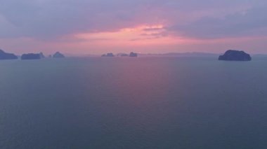 Göz kamaştırıcı günbatımında renkli manzara... günbatımının renkli gökyüzü... 4K çekim Drone 'la... tatlı pembe bulut gökyüzünde mor gölge ile güzel gün batımında....