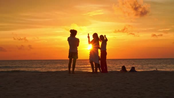 泰国普吉 2023年8月12日游客们在Kata海滩上休息普吉游客们在金色的阳光下在海滩上拍照色彩艳丽的日落映衬着明亮的金色天空背景 — 图库视频影像