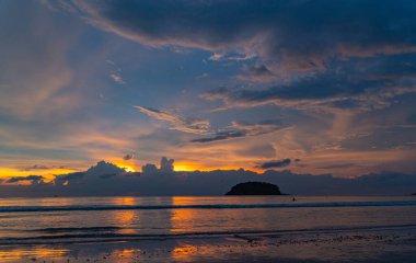 Gün batımı bulutları arasında inanılmaz altın bir ışık. Renkli romantik gökyüzü ve deniz kıyısı, Tayland 
