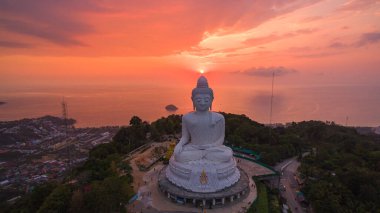 Renkli gündoğumu gökyüzünün havadan görünüşü, arka planda Büyük Buda heykeli ve okyanus. Phuket, Tayland
