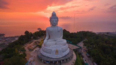 Renkli gündoğumu gökyüzünün havadan görünüşü, arka planda Büyük Buda heykeli ve okyanus. Phuket, Tayland