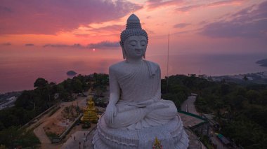 Renkli gündoğumu gökyüzünün havadan görünüşü, arka planda Büyük Buda heykeli ve okyanus. Phuket, Tayland