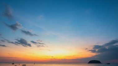 Kata Sahili, Phuket, Tayland 'da okyanusun üzerinde altın gün batımının hızlandırılmış videosu.