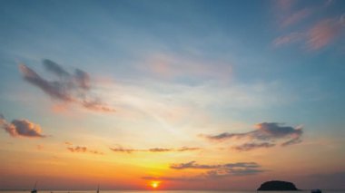 Kata Sahili, Phuket, Tayland 'da okyanusun üzerinde altın gün batımının hızlandırılmış videosu.