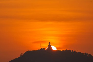 İnanılmaz kırmızı günbatımı gökyüzü ve Phuket büyük Buda sarı güneş çemberinde. Phuket, Tayland