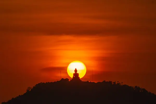 令人惊奇的红色落日的天空和普吉大佛在黄日的圆圈里 泰国普吉 图库照片