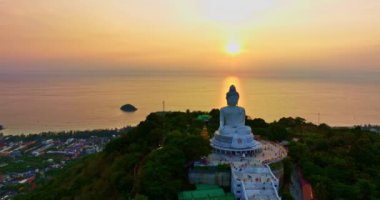 Dağdaki Büyük Buda heykelinin havadan görünüşü ve muhteşem günbatımı gökyüzü, Phuket, Tayland