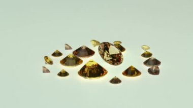 Beyaz arkaplanda farklı boyutlarda sarı elmaslar, video 