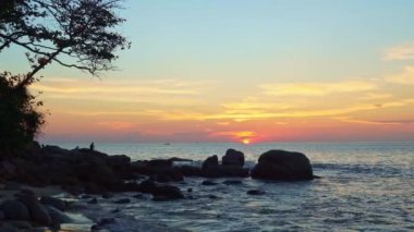 Gün batımında kayalık sahile vuran deniz dalgalarının dramatik görüntüsü, video.
