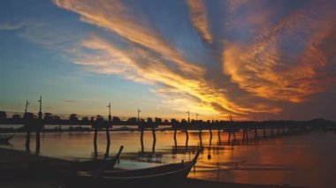 .Güneşin doğuşunda kırmızı bulutların arasından geçen inanılmaz renkli sarı ışık tatlı sarı ışık ışınları ve diğer atmosferik efektlerle deniz arka planında gün doğumunun renkli yansıması..