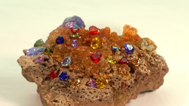 Bunte Herzförmige Diamanten Auf Einem Rohen Opaledelstein Vor Weißem Hintergrund — Stockvideo