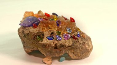 Beyaz bir zemin üzerinde saf opal değerli taşın üzerine yerleştirilmiş renkli kalp şeklinde elmaslar... kalp şeklinde mücevherler sevgililer günü için çok hoş hediyelerdir... güzel renkli elmas arkaplan