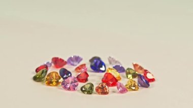 .Güzel, kalp şeklinde, daire şeklinde elmaslar farklı renkte kalp şeklinde elmaslar beyaz zemine dizilmiş pırlantaların pırıltılı ışığı büyüleyici ve güzel görünüyor..