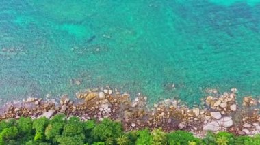 Hava manzaralı turkuaz deniz, kayanın yanındaki yeşil orman, ayak tepesi, adanın etrafını saran kayalar, turkuaz denize karşı pürüzsüz dalgalar, Phuket adasındaki kayalara çarpıyor..