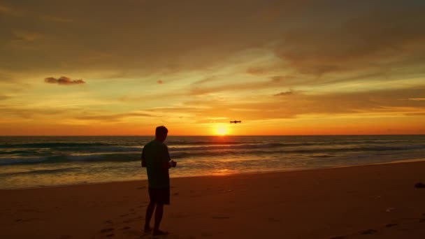 夕阳西下 黄天上乌云密布 一个在日落时分驾驶无人机在五彩斑斓的天空中飞行的人 — 图库视频影像