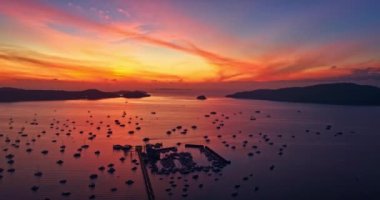 Chalong Piercingleri 'ndeki adaların üzerinde hava hiper yanılma manzarası var. Chalong limanında bir tekne parkı var. Görkemli gündoğumu manzarası. Doğanın inanılmaz ışığı bulutlu.