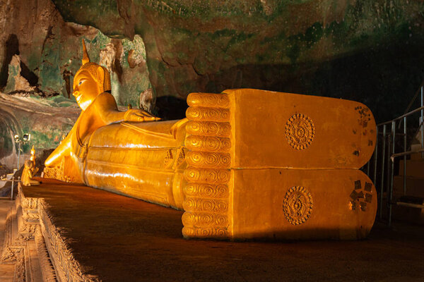 Beautiful golden Reclining Buddha in the cave at Tumsar temple Krabi Thailand.