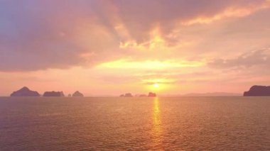 Mağaradaki günbatımında sarı gökyüzünün muhteşem yansıması pelerinin altında.