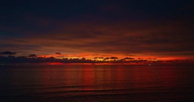 Çam ağaçlarının tepesindeki alacakaranlıkta muhteşem kırmızı gökyüzünde drone kızartıyorlar..
