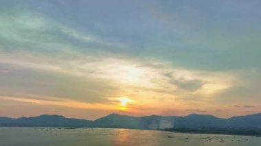 Phuket Denizi 'nin üzerinde, sarı günbatımı gökyüzünde, havadan inanılmaz bir görüntü..