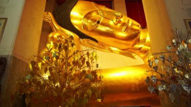 Güzel altın Buda başı Wat Phra Non Chak Si Worawihan Sing Buri Tayland 'da uzanan bir konumda altın Buda güzel yaslanan bir duruşta halk tarafından tapınılır..