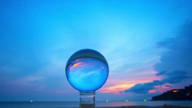 Gün batımında adanın manzarası kristal küre içinde bir kum yığını üzerinde. Plaj videosundaki kristal küre yerinde gün batımı. Doğa videosu doğa ve seyahat konseptinde yüksek kaliteli görüntüler.